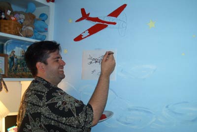 me painting a plane on the wall of my buddy's child's wall